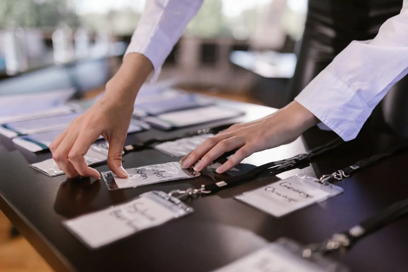 Hands sorting name badges on a registration desk