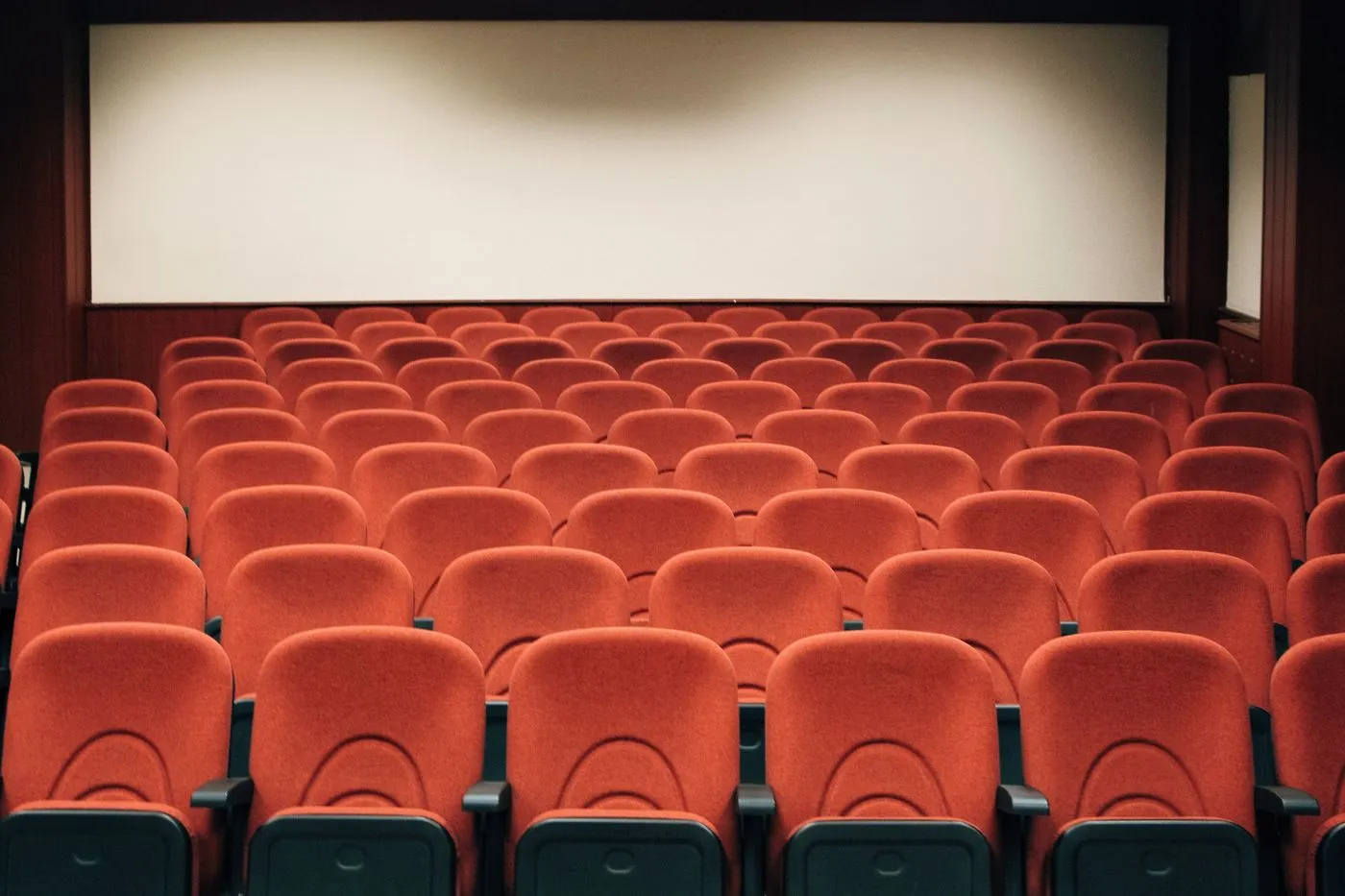 Rows of red seats in an empty auditorium
